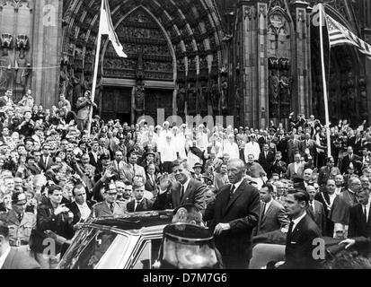 Il presidente statunitense John Fitzgerald Kennedy (m, sventolando) e il Cancelliere federale Konrad Adenauer (m) permanente drive in una vettura opentop attraverso il passato di Colonia un dimostrato entusiasta folla di persone, nel giugno 1963, durante il Kennedy visita in Germania. La cattedrale di Colonia in background. Foto Stock