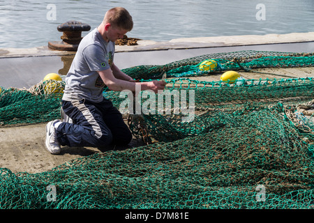 Reti di essere riparata e preparata prima del viaggio di pesca Foto Stock