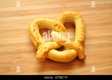 Grandi cosse al forno Pretzel su una tavola di legno Foto Stock