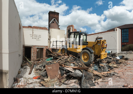 Fine di un epoca e la religione come all'interno della chiesa è demolita in macerie da impianto pesante per fare la strada per le nuove abitazioni e uffici Foto Stock