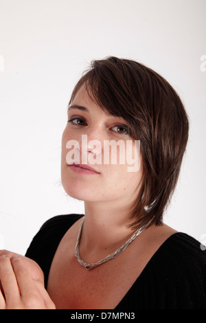 Variazione espressione sul viso di una giovane donna bruna in studio Foto Stock