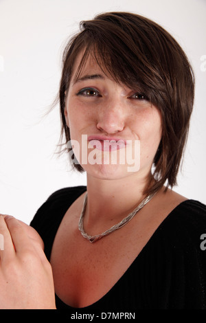 Variazione espressione sul viso di una giovane donna bruna in studio Foto Stock