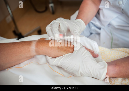 L'infermiera la preparazione di un paziente per una linea IV Foto Stock