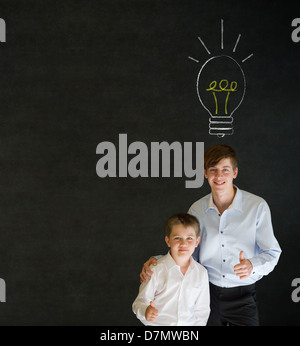 Thumbs up boy vestito come uomo d affari con insegnante l uomo e la brillante idea di chalk lampadina di sfondo su sfondo blackboard Foto Stock