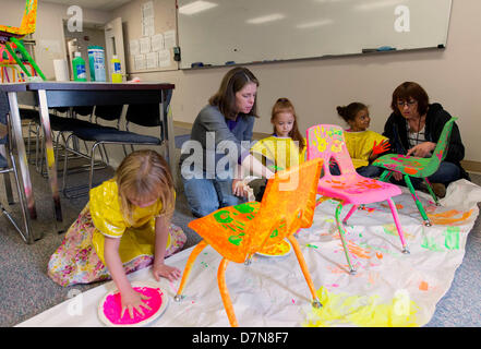 Colorado Springs, Colorado, Stati Uniti d'America. Il 10 maggio 2013. Avvio testa bambini personalizzare sedie con il loro canto delle stampe per raccogliere denaro per mantenere le aule aperte in corrispondenza della loro struttura. Il 17 aprile la comunità di partenariato per lo sviluppo infantile (CPCD), la El Paso County (CO) del concessionario per la testa start lanciato il riempimento di un progetto del sedile di alzarsi in piedi contro la profonda federale di tagli di bilancio che ha devastato la testa Inizio Agenzie e stracciati CPCD 2013-2014 del bilancio da più di mezzo milione di dollari. Credito: ZUMA Press, Inc. / Alamy Live News Foto Stock