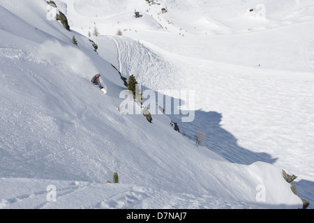 Snowboarder su una ripida collina, andando giù nella polvere Foto Stock