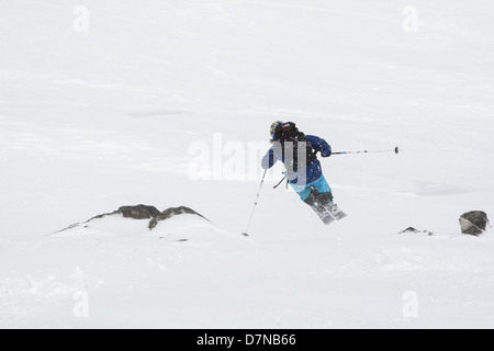 Sciatore saltando una piccola scogliera a fine aprile polvere a molla Foto Stock