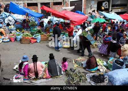 Donne Aymara o cholitas sedute in bancarelle di strada e di verdure a Mercado Rodriguez, un tipico mercato di strada vicino al centro cittadino, la Paz , Bolivia Foto Stock