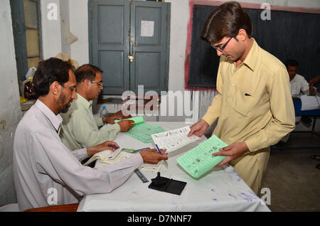 Rawalpindi, Pakistan. 11 maggio 2013. Un uomo prende il suo schede di voto da un'elezione ufficiale in Rwalpindi. Credito: Muhammed Furqan/Alamy Live News Foto Stock