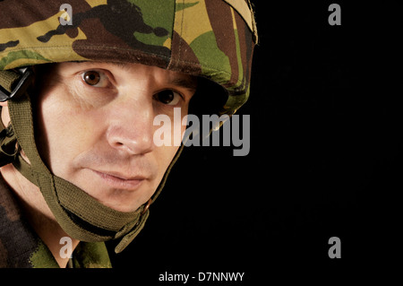 Ritratto di un soldato britannico indossa uniforme militare, contro uno sfondo nero. Foto Stock