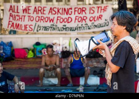 Bangkok, Tailandia. Maggio 11, 2013. Un manifestante utilizza un bullhorn per parlare con altri manifestanti davanti al palazzo del governo. Diverse centinaia di piccola famiglia di scala gli agricoltori si sono accampate a ''Government House'' (l'ufficio del Primo Ministro a Bangkok alla pressione Primo Ministro tailandese Shinawatra Yingluck per offrire su di lei promette di migliorare la situazione della famiglia di agricoltori. Per il popolo€™s movimento per una società giusta (P-move) è un'organizzazione di rete il cui obiettivo è rafforzare la voce dei diversi ma cause relative al lavoro per portare la giustizia per gruppi emarginati in Thailandia, compresi i diritti alla terra Foto Stock