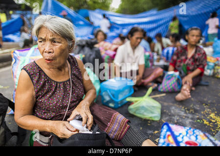 Bangkok, Tailandia. Maggio 11, 2013. Le donne dalla campagna tailandese sedersi nella strada di fronte la sede del governo. Diverse centinaia di piccola famiglia di scala gli agricoltori si sono accampate a ''Government House'' (l'ufficio del Primo Ministro a Bangkok alla pressione Primo Ministro tailandese Shinawatra Yingluck per offrire su di lei promette di migliorare la situazione della famiglia di agricoltori. Per il popolo€™s movimento per una società giusta (P-move) è un'organizzazione di rete il cui obiettivo è rafforzare la voce dei diversi ma cause relative al lavoro per portare la giustizia per gruppi emarginati in Thailandia, compresi i diritti alla terra per smal Foto Stock