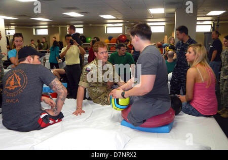 Bethesda, Md.,STATI UNITI D'AMERICA. Maggio 10, 2013. La Gran Bretagna è il principe Harry, al centro dei colloqui con il personale dell'esercito Sgt. Tim Payne, destra e Navy Special Operatore 2 Bo Reichenbach, sinistra, combattenti feriti sottoposti a trattamento a Walter Reed Militare Nazionale Medical Center di Bethesda, Md., 10 maggio 2013. .Credito: Donna miglia / DoD via CNP/DPA/Alamy Live News Foto Stock