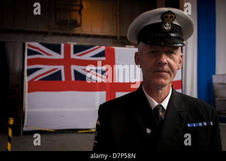 Un Chief Petty Officer in prossimità della Marina di alfiere bandiera sulla hangar deck durante una gita con il pubblico in generale a bordo della Royal Navy la portaerei HMS illustri nel corso di un pubblico aperto-giorno di Greenwich. Illustri ancorato sul fiume Tamigi, consentendo al contribuente di pubblico tour i suoi mazzi di carte prima del suo imminente decommisioning. Il personale della Marina ci ha aiutato con il PR evento oltre il fine settimana di maggio, storicamente la casa di Gran Bretagna flotta navale. Foto Stock