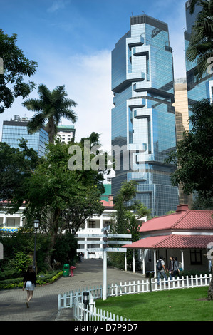 Dh Hong Kong Park Central HONG KONG ragazza camminare attraverso il parco di Lippo grattacielo in costruzione Foto Stock