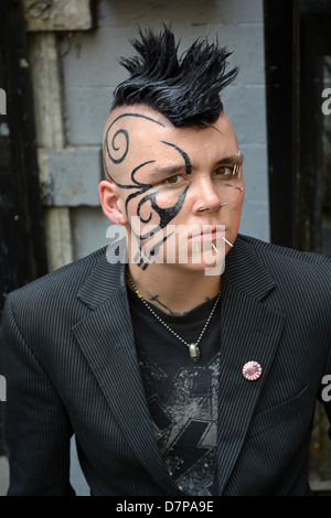 Ritratto di un sesso persona ambigua nel Greenwich Village con un taglio di capelli Mohawk, faccia tatuaggi e piercing multipli Foto Stock