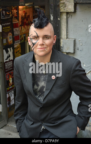 Ritratto di un sesso persona ambigua nel Greenwich Village con un taglio di capelli Mohawk, faccia tatuaggi e piercing multipli Foto Stock