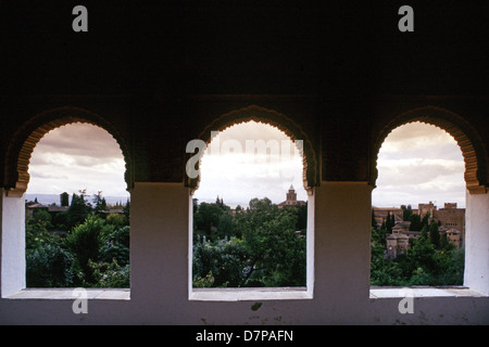 Vista attraverso Windows Moresco verso la vicina collina e i giardini di Albaicin in Alhambra un palazzo e fortezza complesso situato nella città di Granada in Andalusia comunità autonoma nel sud della Spagna Foto Stock