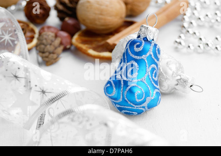 Il Natale di vetro coni fir con spezie e il nastro sul tavolo bianco Foto Stock