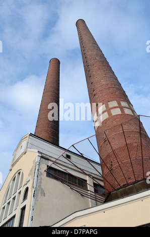 Edificio industriale e due mattone camino contro il cielo blu Foto Stock