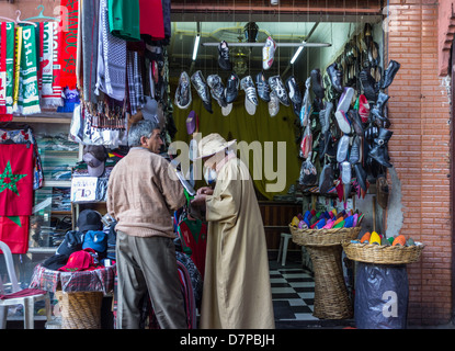 Marrakech in Kessabine Souk. Acquisto di formatori a un abbigliamento e calzatura stallo. Foto Stock