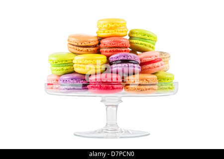 Tradizionale Francese macaron colorati in una torta di vetro stand su sfondo bianco Foto Stock