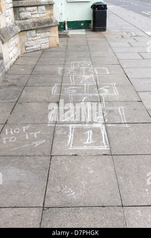 Tradizionale per bambini in vecchio stile hop scotch griglia di gioco disegnato in gesso su marciapiede Foto Stock