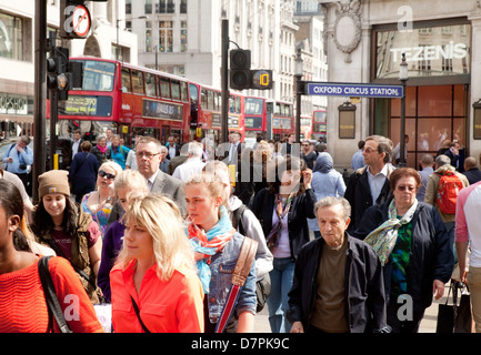 Una folla di pedoni persone attraversando la strada a Oxford Circus, central London, Regno Unito Foto Stock