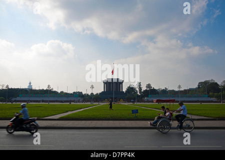 Paesaggio urbano orizzontale di ciclomotori e moto la guida ha superato il Mausoleo di Ho Chi Minh nel centro di Hanoi in una giornata di sole. Foto Stock