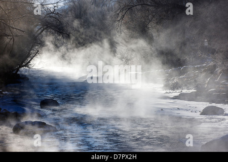 Vapore sorge su un sub-zero mattina dalla neve e ghiaccio soffocato Arkansas River, che corre attraverso il quartiere del centro storico Foto Stock