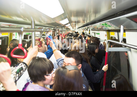 dh Mass Transit Railway MTR HONG KONG folla passeggeri pendolari trasporti cinese, treno sotterraneo trafficato pubblico standing Foto Stock