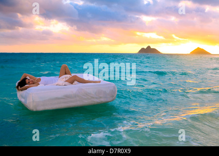 La donna nel suo letto alla deriva in mare Foto Stock