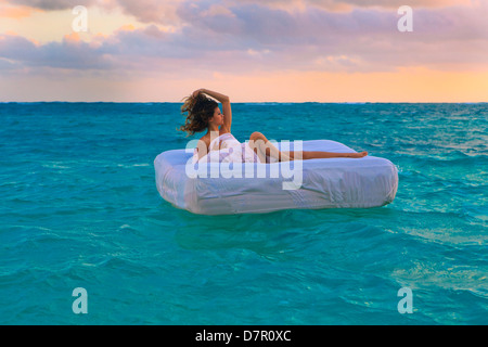 La donna nel suo letto alla deriva in mare Foto Stock