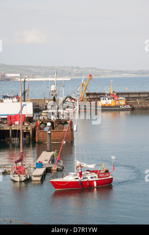 Il bianco e il rosso yacht di entrare nel Porto di Newlyn Cornwall Regno Unito Foto Stock