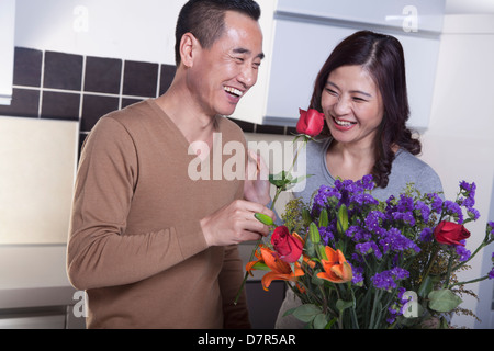 Coppia matura con bouquet di fiori, uomo tenendo una rosa Foto Stock