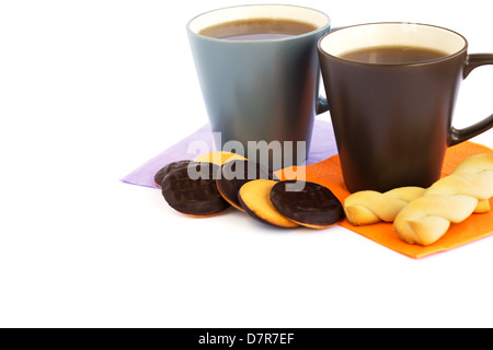 Tazze di tè e biscotti isolati su sfondo bianco. Foto Stock