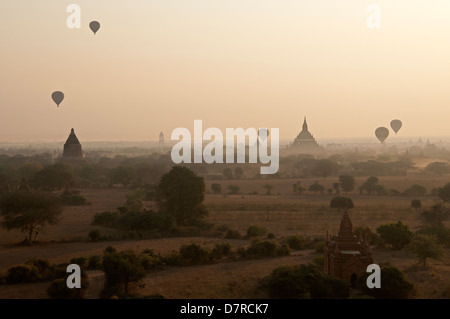 Sagome di palloncini fluttua sopra i templi del misty pianure di sunrise Bagan Myanmar (Birmania) Foto Stock