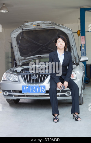 Imprenditrice seduta su Auto con cappa aperta Foto Stock