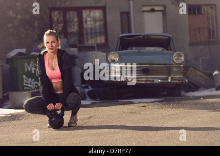 Appoggio donna fitness sulla strada avente una pausa dopo esercizio Foto Stock