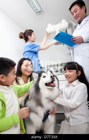 Donna con bambini e cane in veterinario dell'ufficio Foto Stock