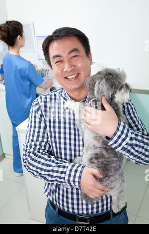 Uomo con cane in veterinario dell'ufficio Foto Stock