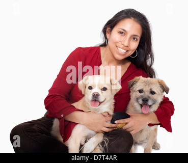 Ritratto di donna che abbraccia i suoi cani, studio shot Foto Stock
