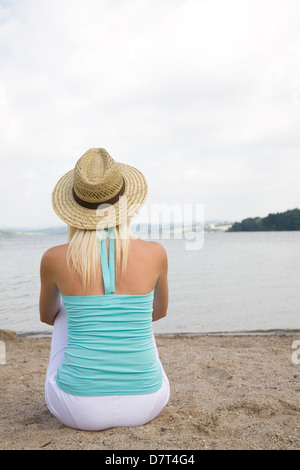 Donna bionda, cappello di paglia, ESC si voltò indietro, mare, estate, primavera, relax Foto Stock