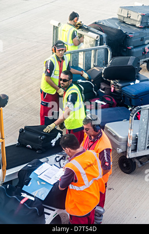 Swissport bagagli carico dei bagagli in attesa tramite nastro trasportatore agli aeromobili di Lanzarote Spagna Foto Stock