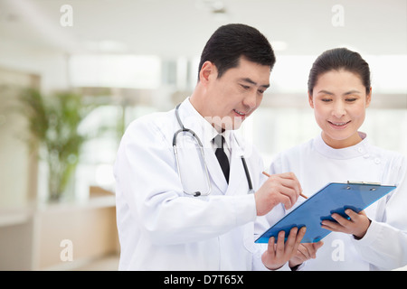 Medico e infermiere guardando Record medici Foto Stock