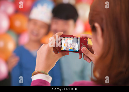 Madre tenendo la foto del padre e figlio nel Figlio il compleanno Foto Stock