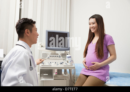 Medico con una donna in stato di gravidanza Foto Stock