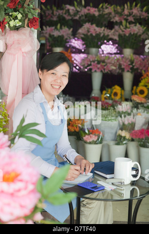 Fioraio lavorando in negozio di fiori Foto Stock