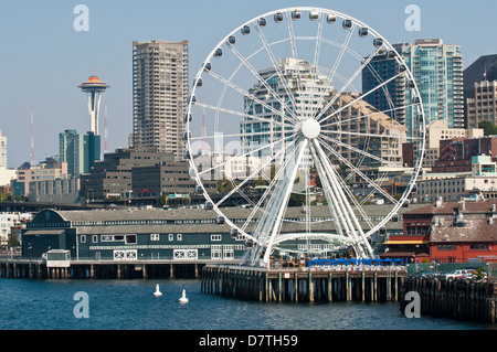 Stati Uniti d'America, WA, Seattle. Drammatica downtown waterfront include iconico lo Space Needle e il Seattle Grande Ruota Foto Stock