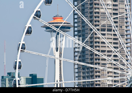 Stati Uniti d'America, WA, Seattle. Drammatica downtown waterfront include iconico lo Space Needle e il Seattle Grande Ruota Foto Stock